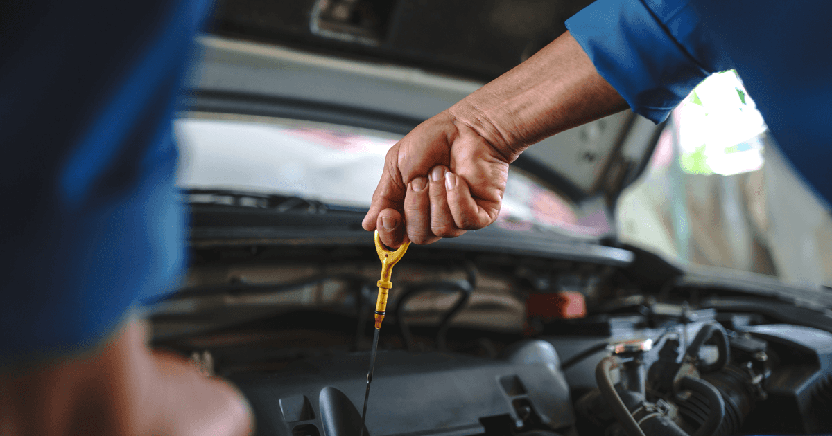 Mechanic's hands performing an oil change on a car