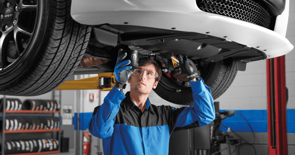 Mopar technician installs oil filter in car