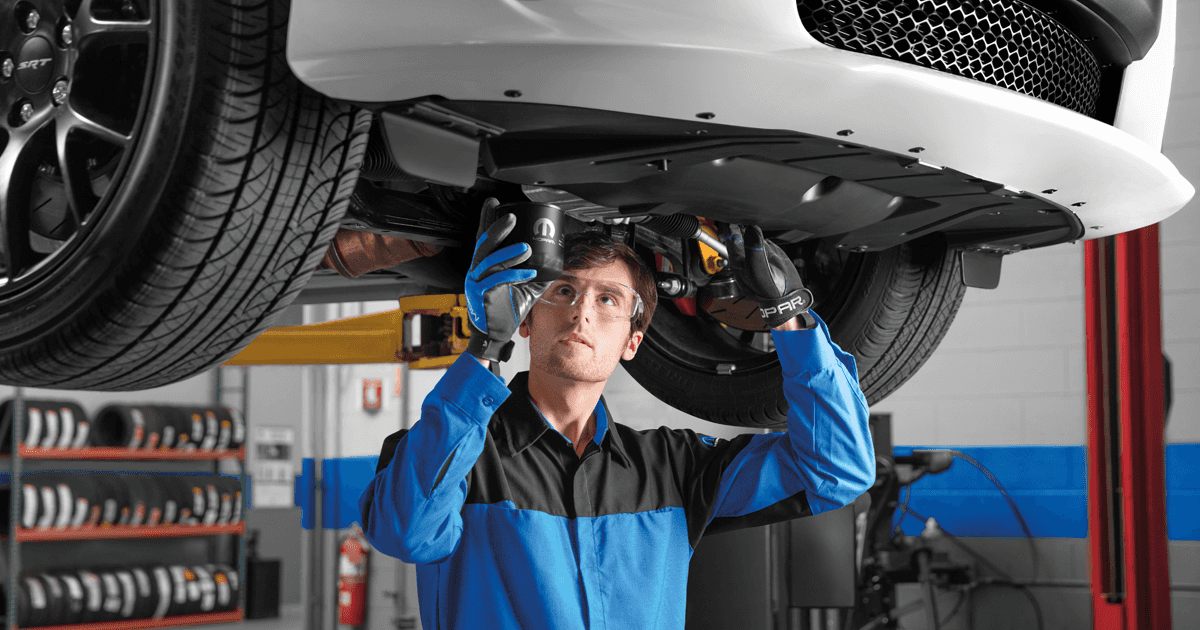 Mopar technician installs oil filter in car