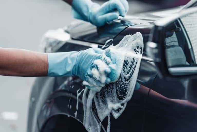 A soapy sponge against a car