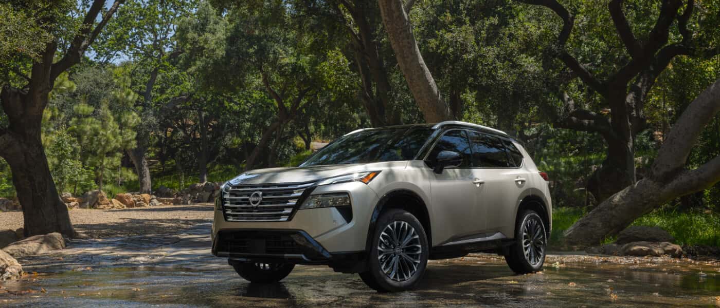 2026 Nissan Rogue Exterior Driving Through Forest