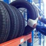 Man grabbing a tire off the rack for Jeep service