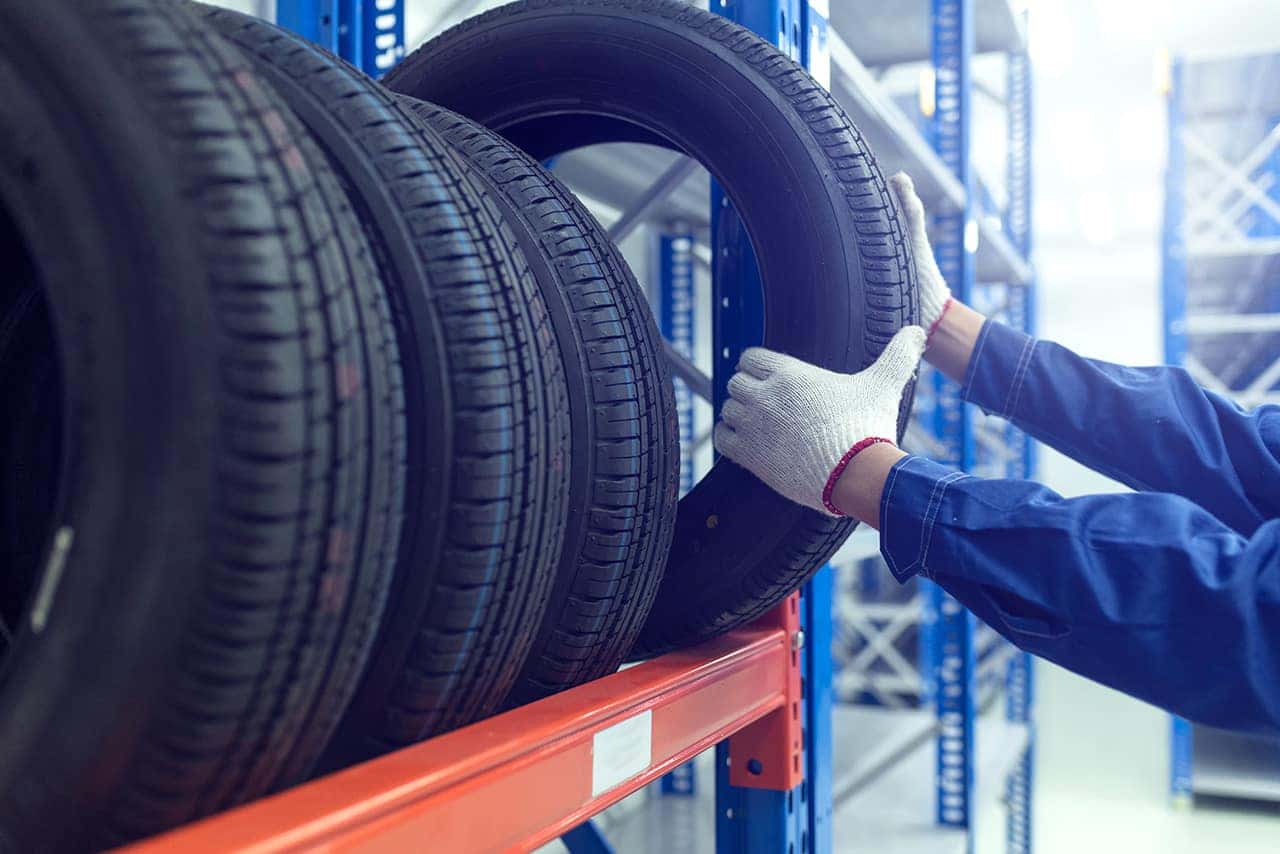Man grabbing a tire off the rack for Jeep service