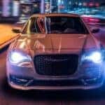 A white 2023 Chrysler 300S illuminated in the city night