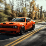An orange 2023 Dodge Challenger SRT driving down a forested road