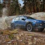2025 Subaru Crosstrek going down a dirt road with dust kicking up.