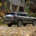 2025 Sbaru Outback parked in front of a cabin in the fall