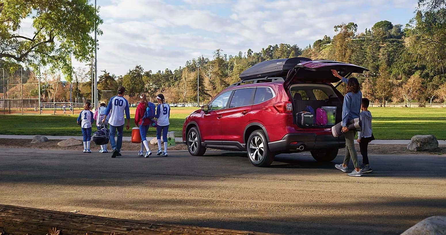 Red Subaru Ascent parked outside a softball field.