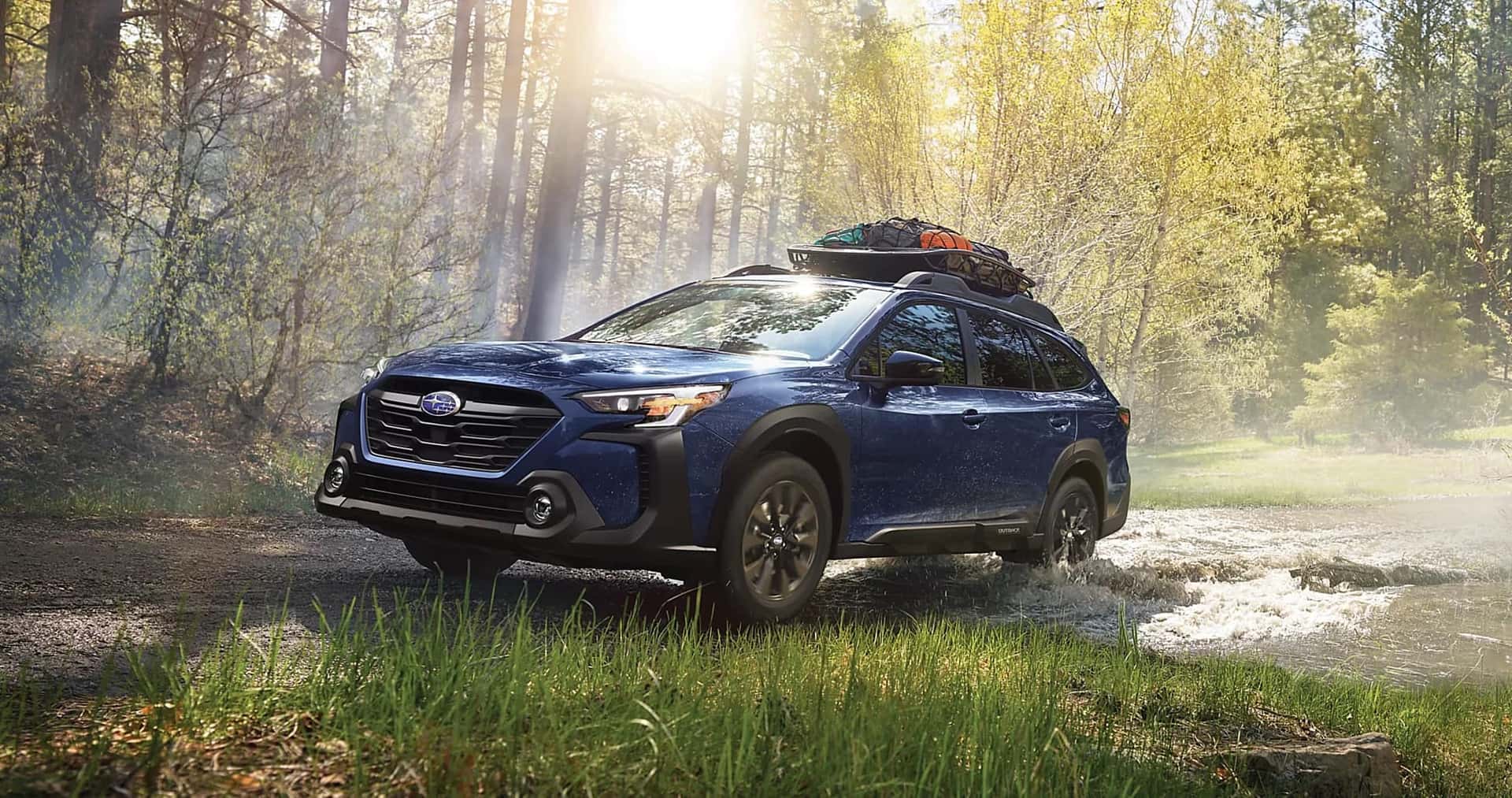 A blue Subaru Outback driving in the forest.
