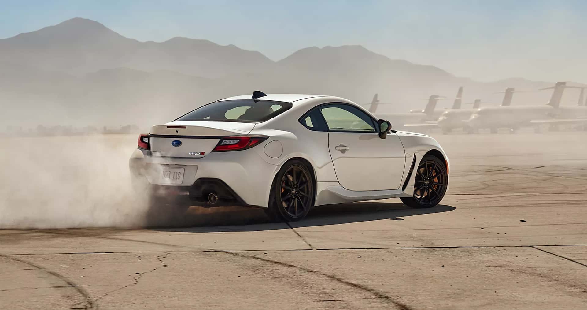 A white Subaru BRZ on the tarmac doing a donut