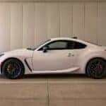A white Subaru BRZ in a garage.
