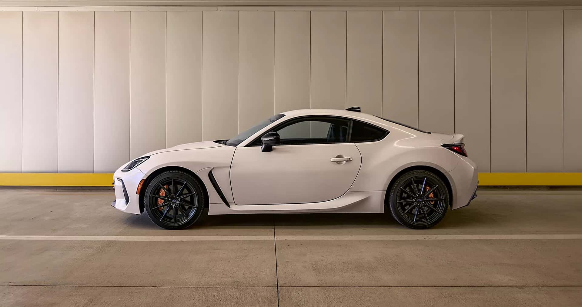 A white Subaru BRZ in a garage.