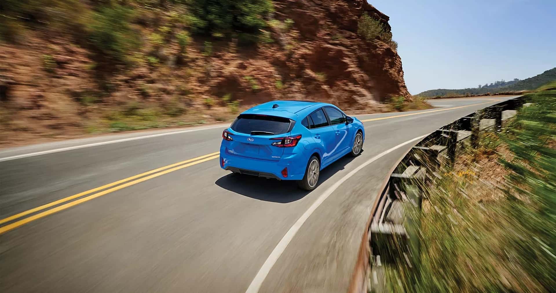 a blue subaru impreza driving down the road