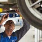 A Subaru service tech works on a Subaru in shop.
