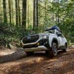 A white 2023 Subaru Forester going down a dirt road.