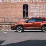 Red 2025 Subaru Crosstrek outside of a brick bullding.