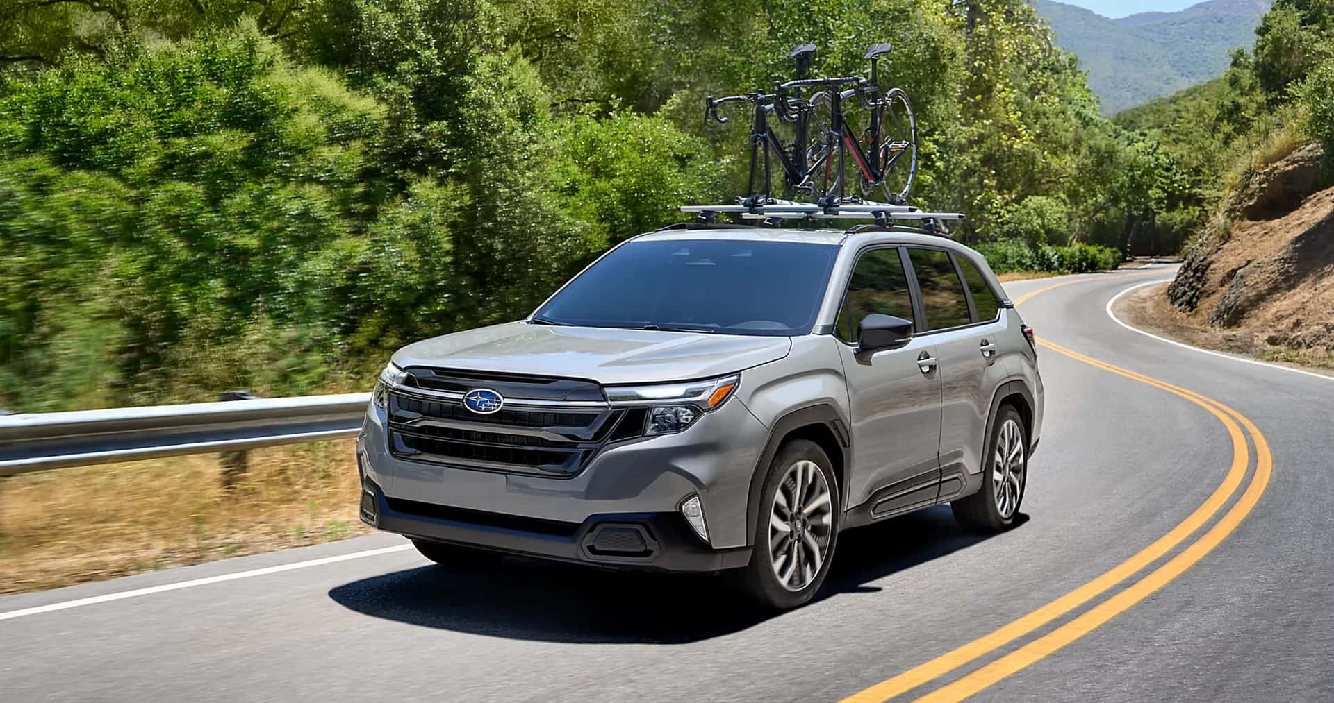 Grey Subaru Forester driving down a country road.