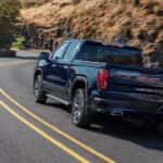 a blue 2025 GMC Sierra 1500 Denali from the rear at an angle.
