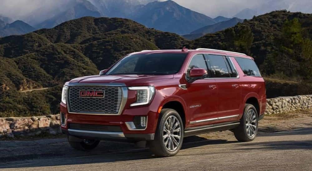 A red 2021 GMC Yukon XL Denali parked at an overlook.