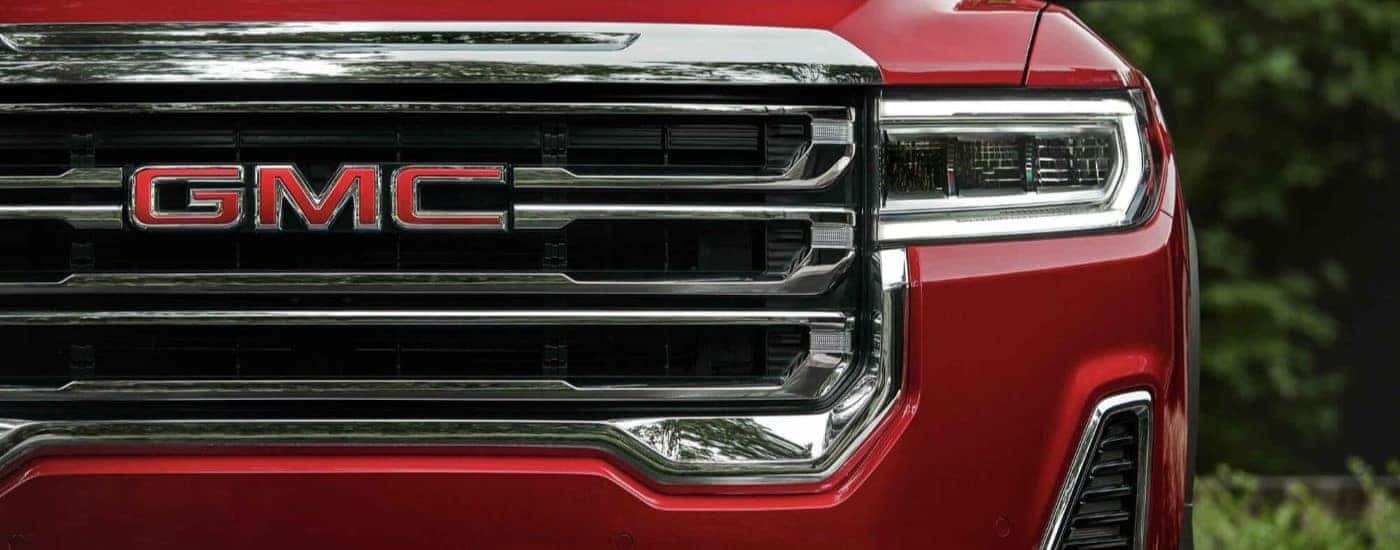 A red 2023 GMC Acadia from the front after leaving a used GMC dealer.