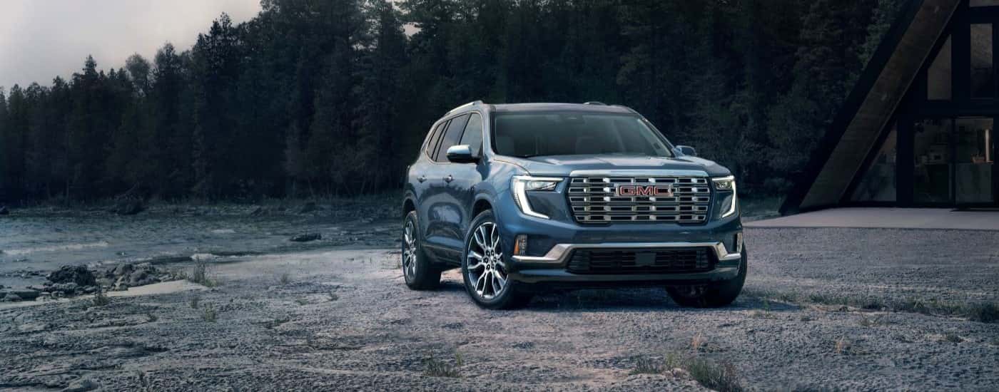 Blue 2024 GMC Acadia parked off road