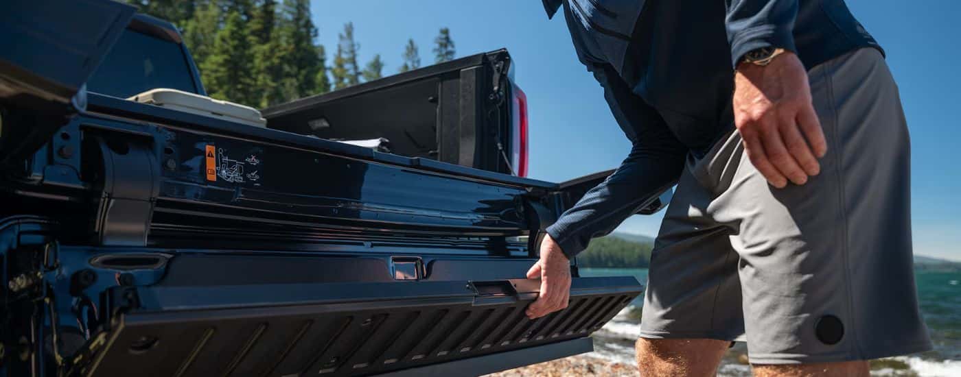 A man using the Multipro Tailgate on a Black 2026 GMC Sierra 1500.