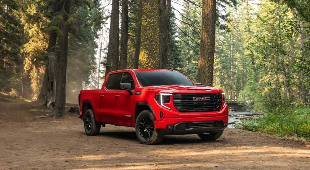 A red 2026 GMC Sierra 1500 parked in the woods.