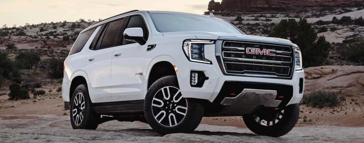 A white 2022 GMC Yukon parked on rocky terrain.