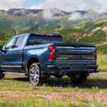A blue 2025 Chevy Silverado 1500 High Country from the rear at an angle.