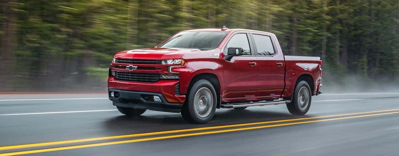 A red used 2021 Chevy Silverado 1500 Z71 driving down a road