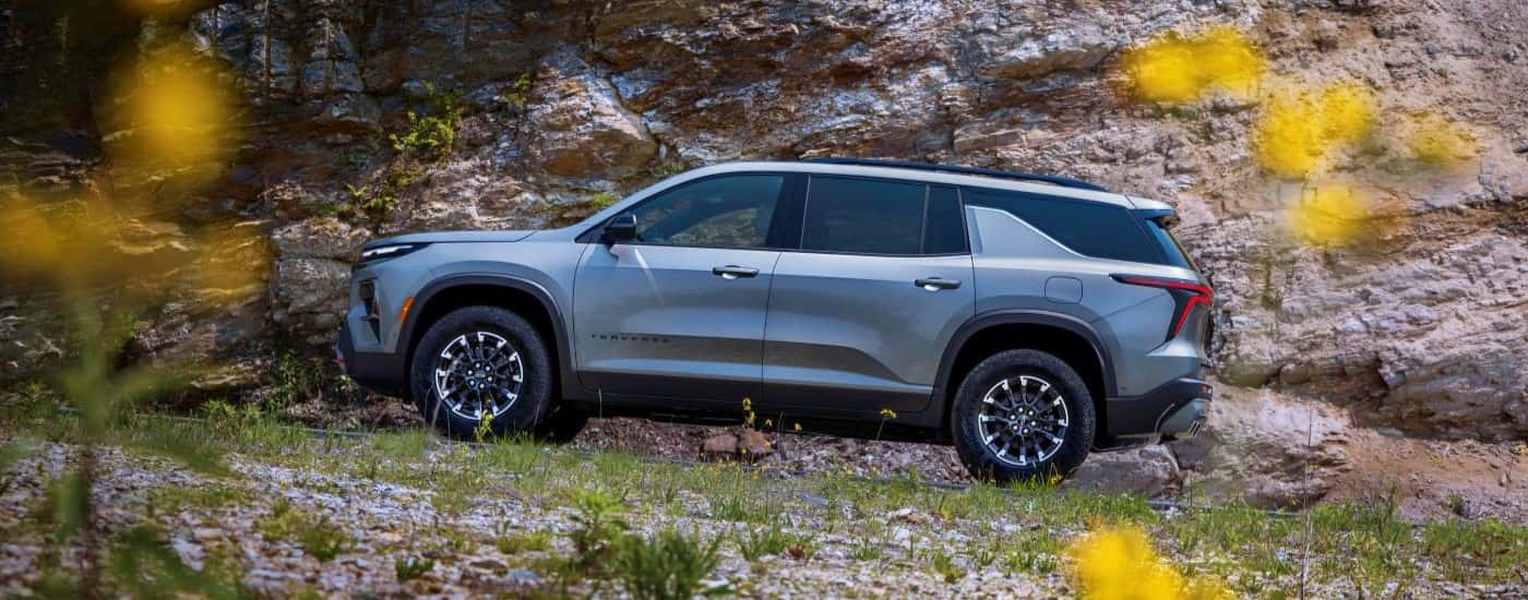Side of a grey 2025 Chevy Traverse Z71 parked near a flower field.