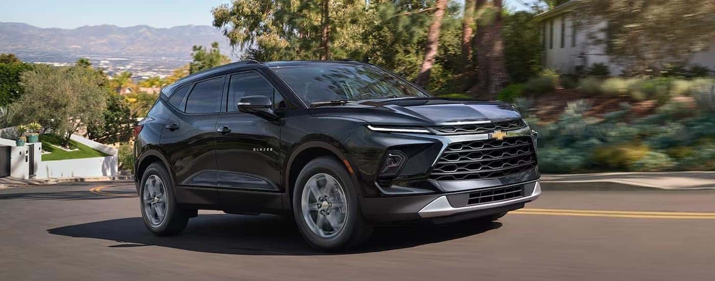 Black 2026 Chevy Blazer driving down a suburban street