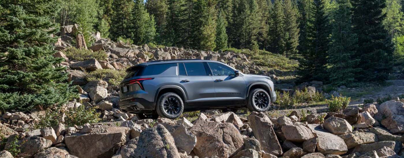 A gray 2026 Chevy Traverse Z71 shown driving a rocky dirt road.