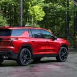 A red 2026 Chevy Traverse RS parked in a driveway.