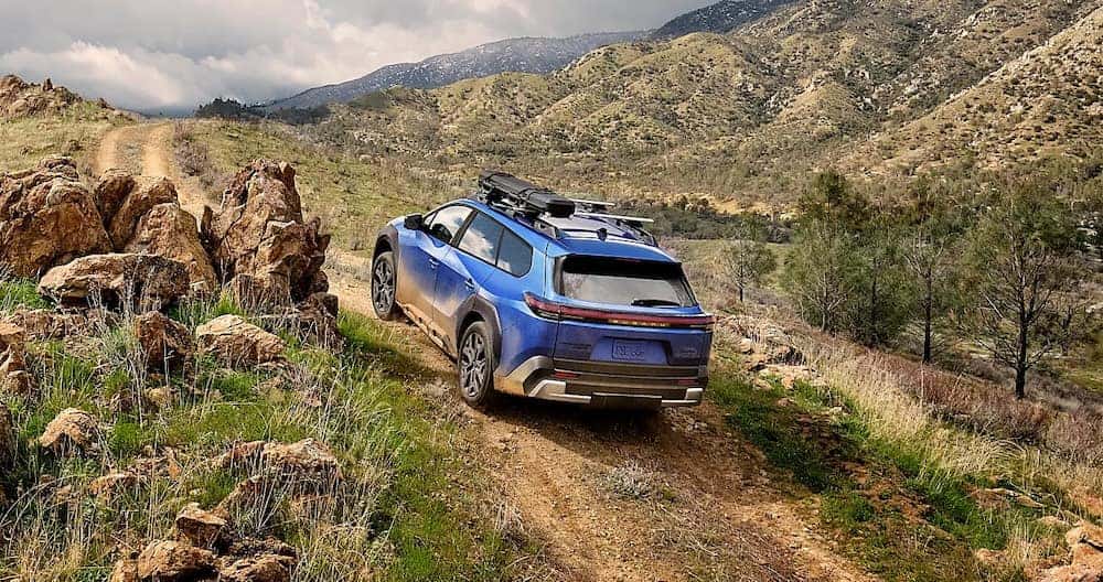 A bright blue 2026 Subaru Trailseeker driving up a mountain trail