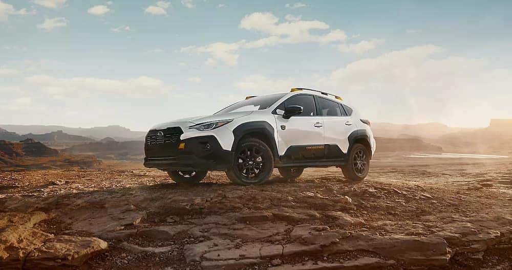 A white 2026 Subaru Crosstrek Wilderness parked in the desert with mountains in the background