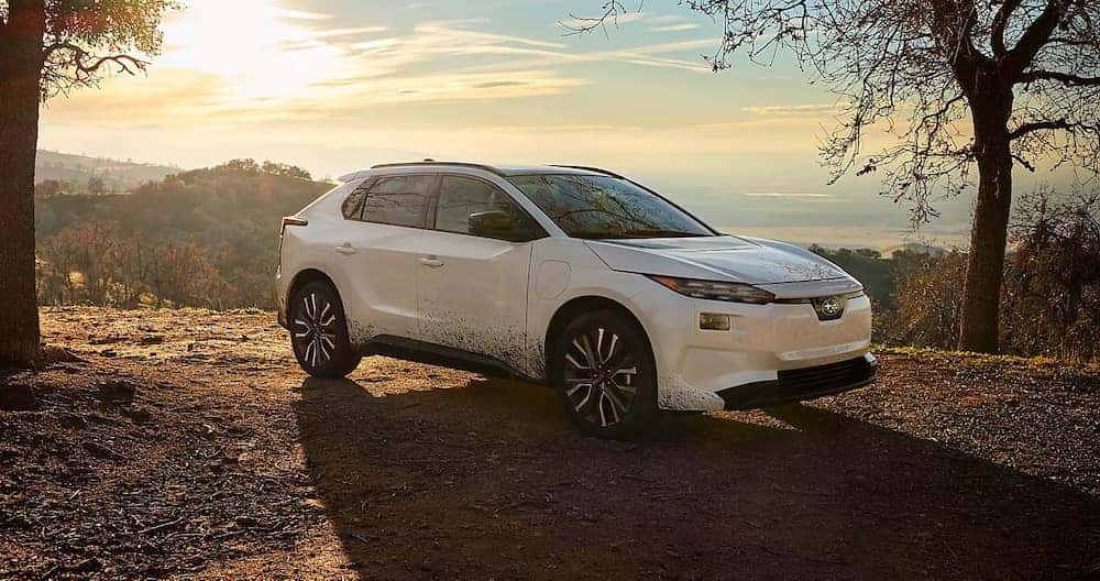 A white 2026 Subaru Solterra SUV parked in the mountains at sunset