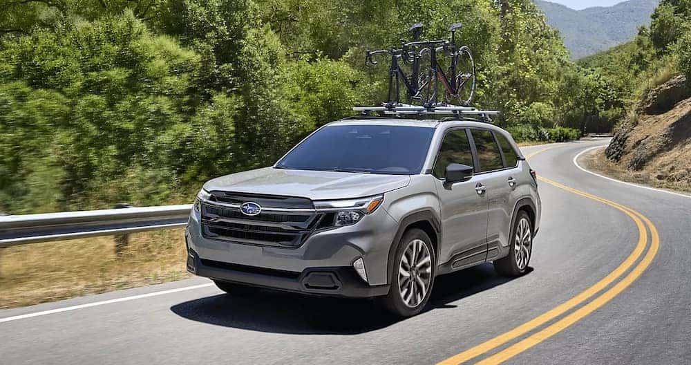 A gray 2026 Subaru Forester SUV with bicycles on its roof rack
