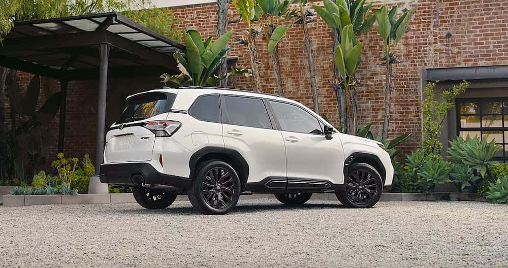 A white Subaru Forester parked outside a brick building