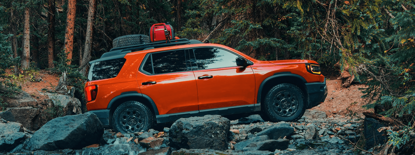 The new 2026 Honda Passport is shown driving over harsh rocks with ease, preparing to go on an off-road excursion.