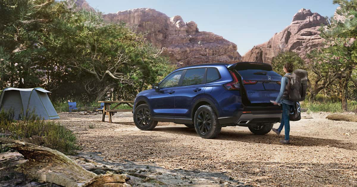 The new 2026 Honda CR-V sits parked with the trunk opening toward us as a campsite is set up.