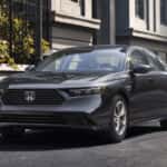 A dark grey 2026 Honda Accord parked in front of a row of townhouses.
