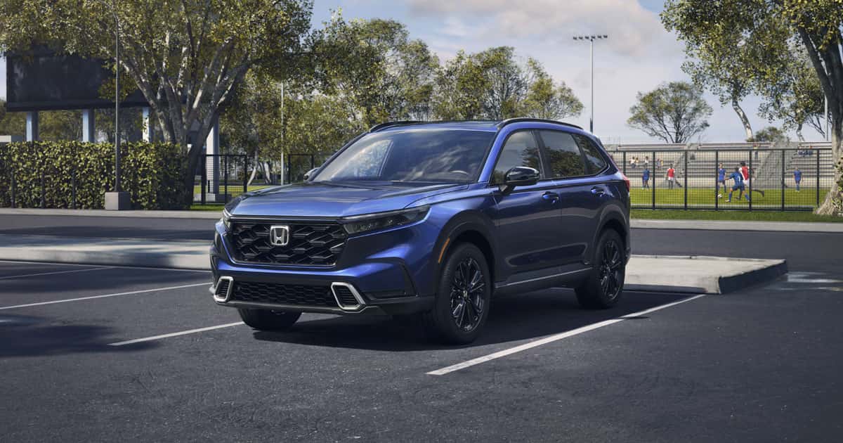 A blue Honda CR-V parked by a soccer field.