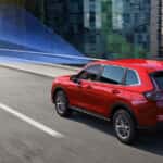 A Honda CR-V on a highway with safety features scanning the street and detecting the speed limit.