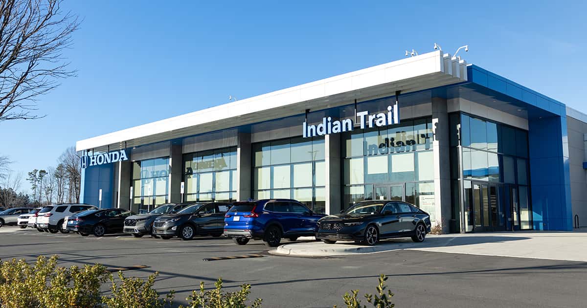 The storefront of the Honda of Indian Trail dealership and vehicle lot.