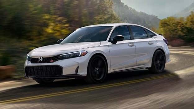 2026 Honda Civic Si sedan in Platinum White Pearl cornering on a mountain road