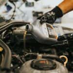 Hands Pouring Oil to Engine