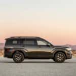The right side view of the Hyundai SANTA FE XRT stopped with the mountains under the sunset in the background.