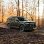 SUV Navigating Forest Trail During Autumn