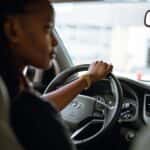 Woman Wearing Gold Watch Driving a Car